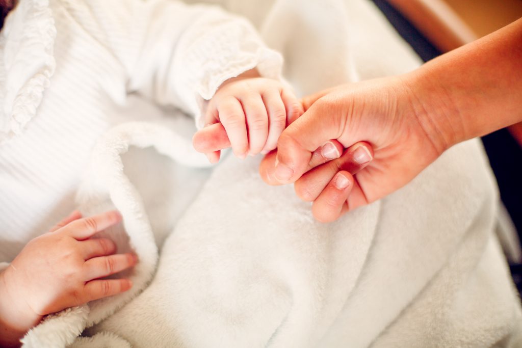 le bébé attrape la main de maman
