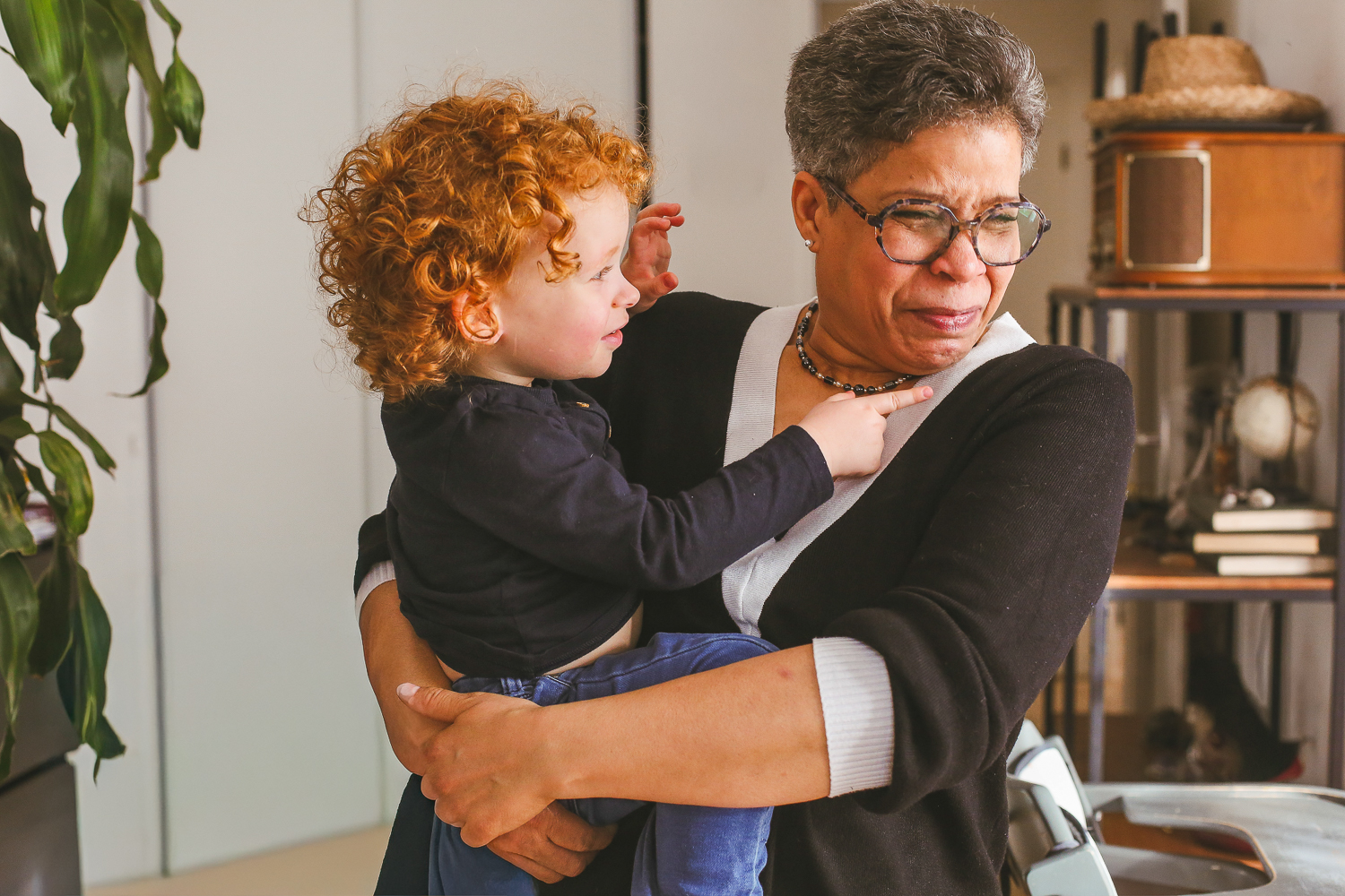 la grand-mère fait un calin à son petit fils, dans la maison