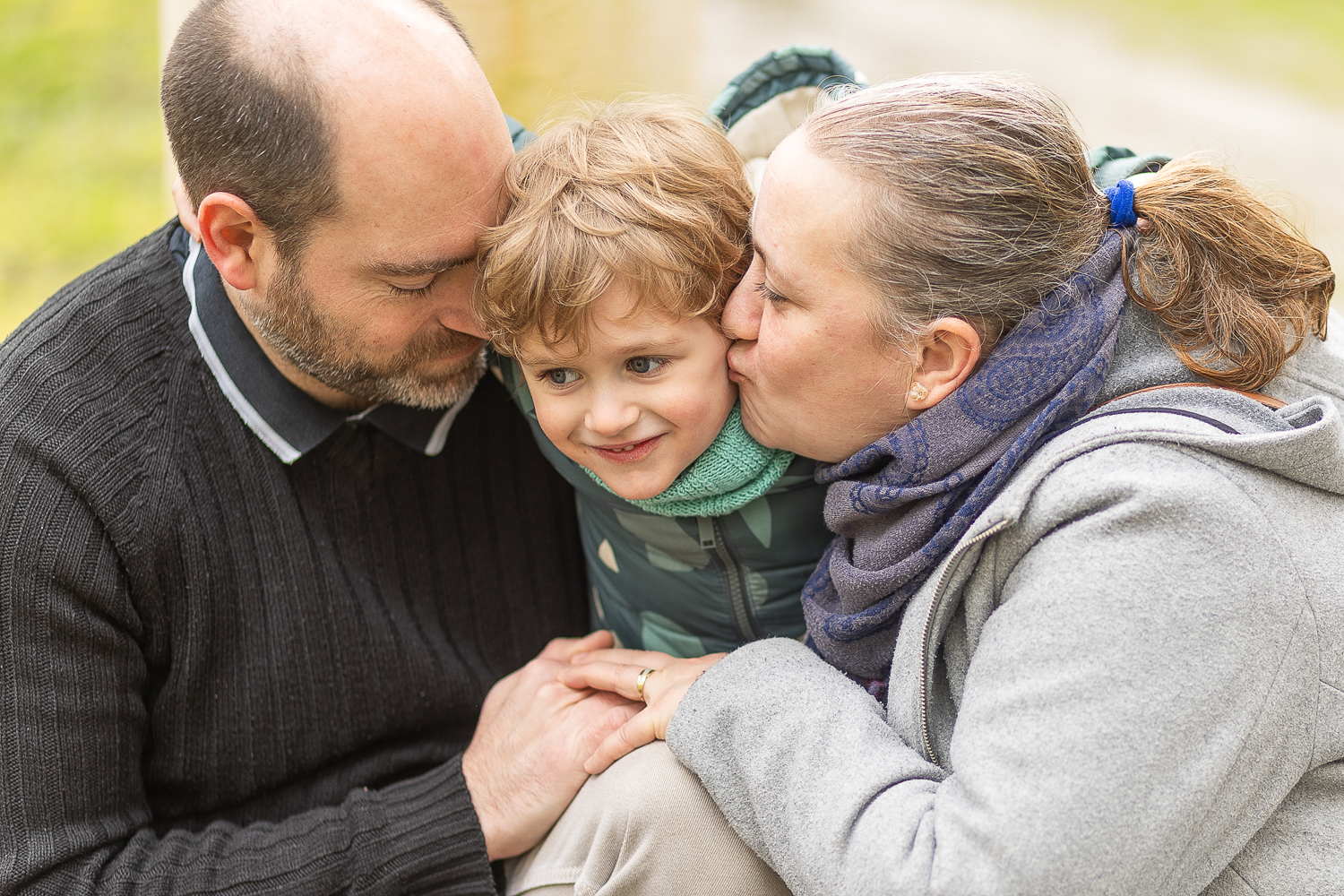 la famille fait un bisou, dans le parc