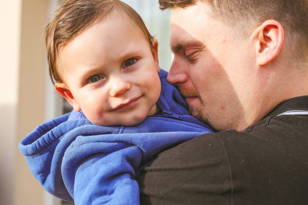 le petit garçon fait un calin à son papa
