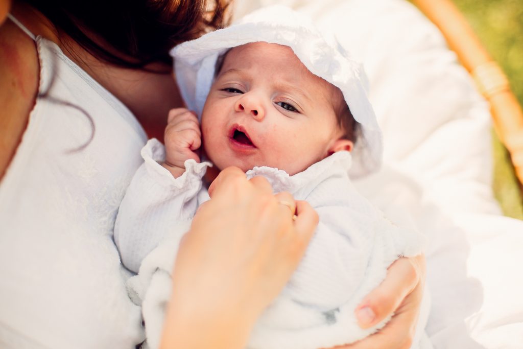 une maman et son bébé dans les bras dans son jardin