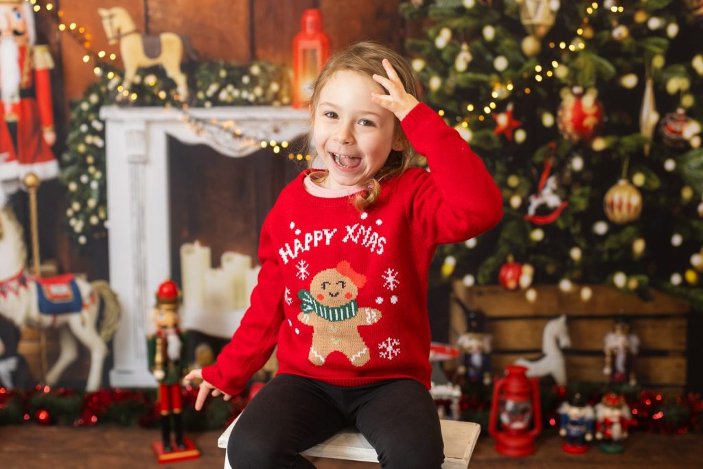 Photo d'une jeune fille dans un studio avec un décor de Noel