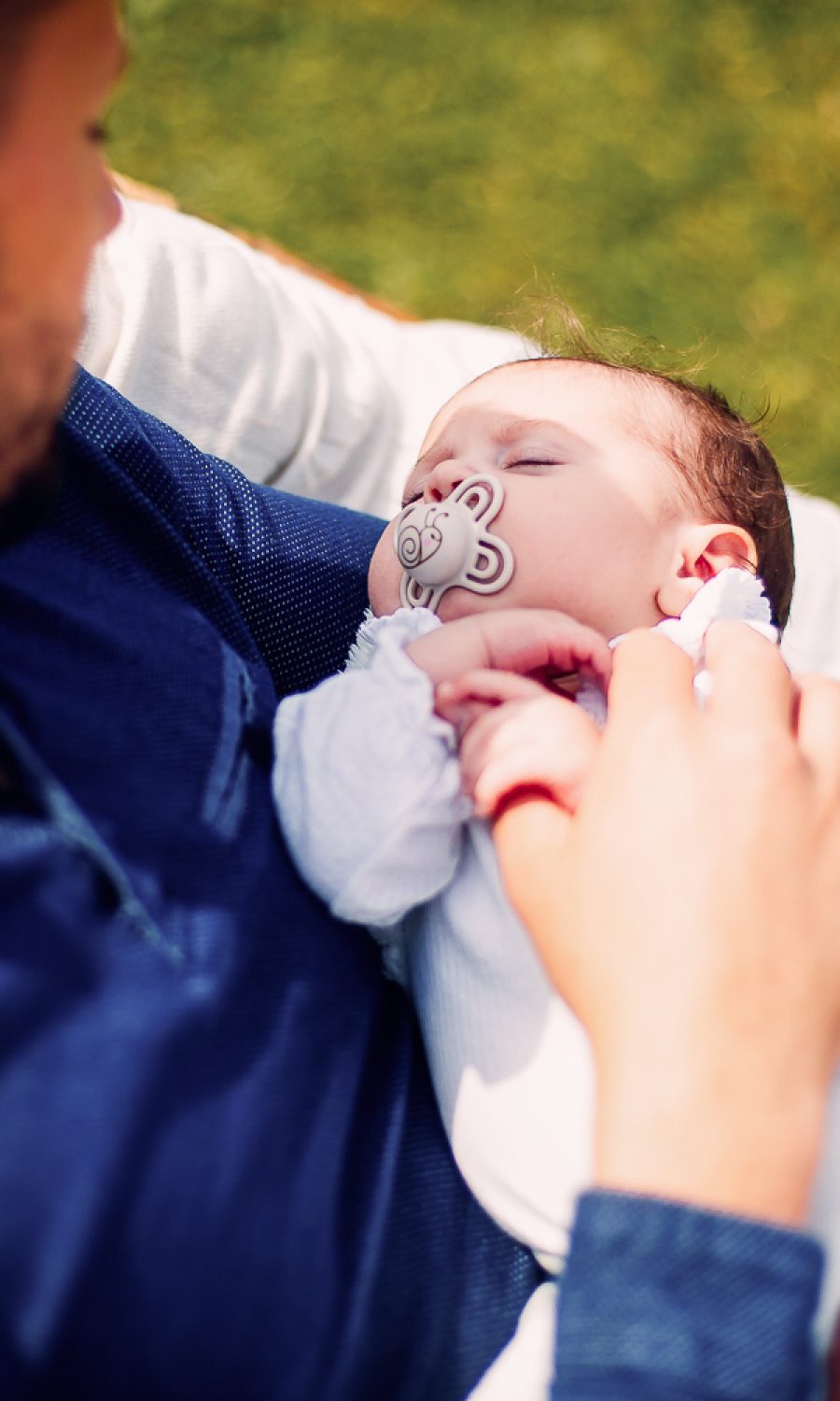 Un papa et son bébé nouveau né à son domicile assis sur le transat